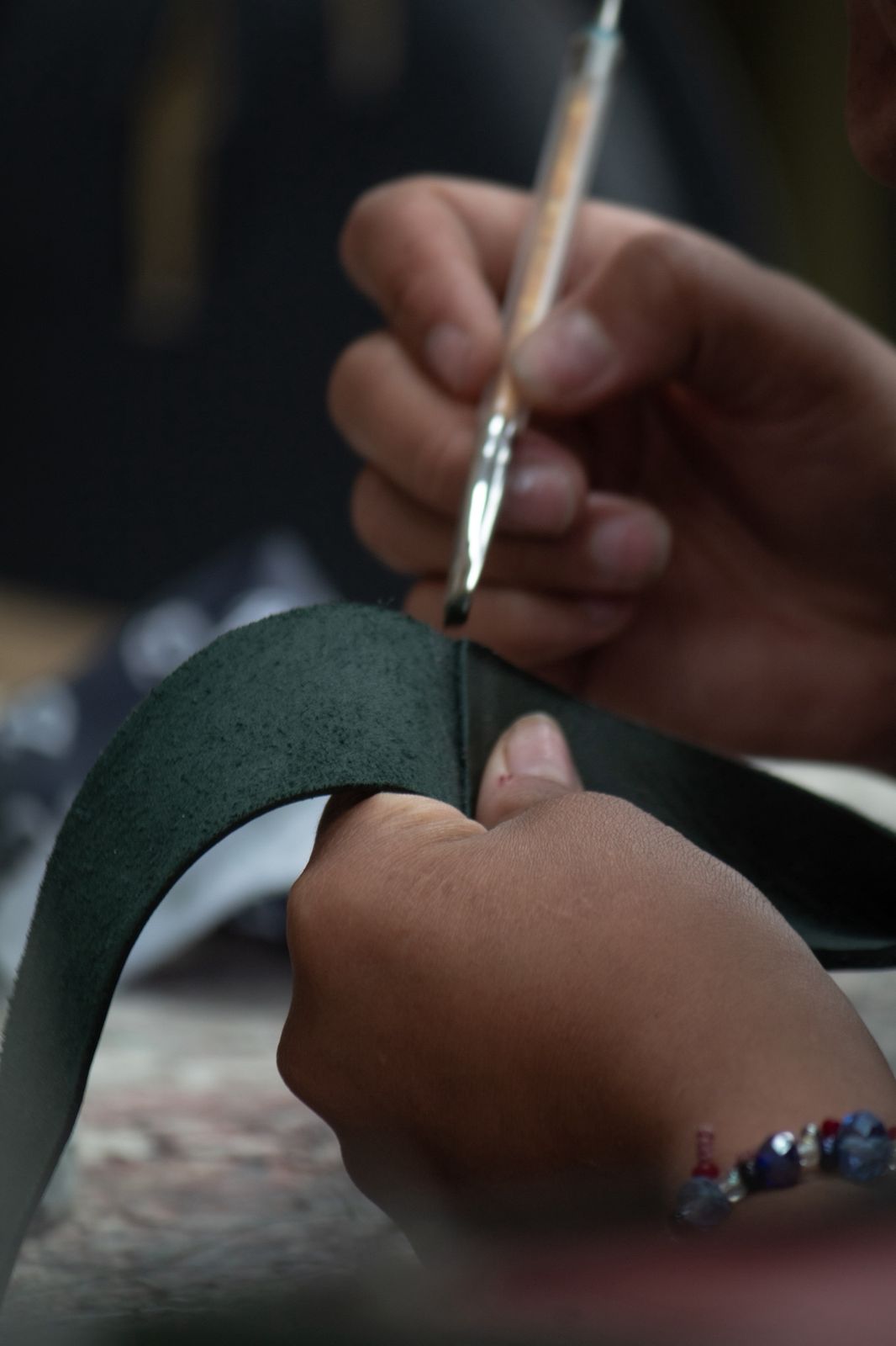 Bobby Golf artisan hand-stitching Pine Green full-grain leather — four generations of leather craftsmanship